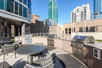 A patio with a table and chairs overlooking a cityscape.